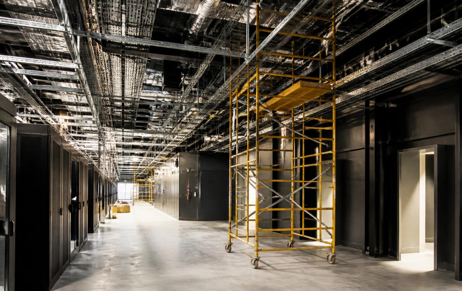 Rolling scaffold tower set for overhead work in a data center corridor